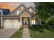 Inviting exterior view of a two-story home featuring a well-manicured lawn, two-car garage, and charming front porch at 121 Bridgegate Dr, Cary, NC 27519