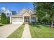 Inviting exterior view of a two-story home featuring a well-manicured lawn, two-car garage, and charming front porch at 121 Bridgegate Dr, Cary, NC 27519