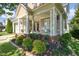 Inviting front porch with white columns, rocking chairs, and well-maintained landscaping at 121 Bridgegate Dr, Cary, NC 27519