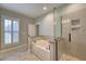 Bright main bathroom features soaking tub, glass shower, and neutral tile at 121 Bridgegate Dr, Cary, NC 27519
