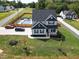 An aerial shot showing a home with a fenced yard, a pool, and a manicured lawn in a suburban neighborhood at 1302 Reading Ct, Burlington, NC 27217