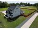 Aerial side view of the house highlighting the spacious yard, fence, and proximity to nature at 1302 Reading Ct, Burlington, NC 27217