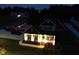 Well-lit front exterior showcasing covered porch, manicured lawn, and landscape lighting at 1302 Reading Ct, Burlington, NC 27217