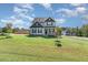 Well-maintained two-story home with a lush green lawn, mature trees, and manicured landscaping at 1302 Reading Ct, Burlington, NC 27217