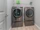 Modern laundry room featuring gray washer and dryer set with storage pedestals at 1302 Reading Ct, Burlington, NC 27217
