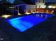 Relaxing in-ground pool with stunning blue lighting and surrounding patio at night at 1302 Reading Ct, Burlington, NC 27217