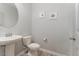 This powder room has a pedestal sink and toilet with wood-look tile flooring at 1302 Reading Ct, Burlington, NC 27217
