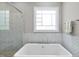 Close up view of a soaking tub showcasing tile accent wall and window at 1308 Mackinaw Dr, Wake Forest, NC 27587