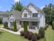 Beautifully landscaped two-story home with manicured lawn and covered porch with stairs to front door at 1308 Mackinaw Dr, Wake Forest, NC 27587