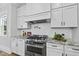 Gourmet kitchen featuring stainless steel range, white cabinetry, granite countertops, and tile backsplash at 1308 Mackinaw Dr, Wake Forest, NC 27587