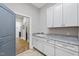Bright laundry room with granite countertops, white cabinetry, and modern fixtures at 1308 Mackinaw Dr, Wake Forest, NC 27587