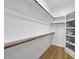 Walk-in closet with hardwood floors, multiple shelves and hanging rods at 1308 Mackinaw Dr, Wake Forest, NC 27587