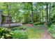 Backyard with mature trees, wooden deck and a stone pathway at 1416 Dunbar Ct, Cary, NC 27511