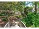 Landscaped backyard featuring a screen porch and wood stairs surrounded by lush greenery at 1416 Dunbar Ct, Cary, NC 27511