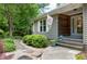 Inviting entrance with stone pathway, lush bushes, and a seasonal decorative flag at 1416 Dunbar Ct, Cary, NC 27511