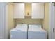 Convenient laundry room features washer, dryer, upper cabinets, and bright yellow walls at 1416 Dunbar Ct, Cary, NC 27511