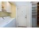 Laundry area with ample storage cabinets, access door, and a separate shelved storage area at 1416 Dunbar Ct, Cary, NC 27511