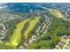 Aerial view of a neighborhood with houses bordering a golf course and mature trees at 1605 Heritage Club Ave, Wake Forest, NC 27587