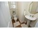 Cozy half bath with hardwood floors, pedestal sink, and decorative mirror for guests at 1605 Heritage Club Ave, Wake Forest, NC 27587
