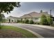 Exterior of the clubhouse featuring a welcoming entrance, manicured landscaping and neutral siding at 1605 Heritage Club Ave, Wake Forest, NC 27587