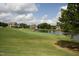 Scenic view of the golf course with a pond, lush green grass, and beautiful homes in the background at 1605 Heritage Club Ave, Wake Forest, NC 27587