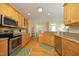 Spacious kitchen with stainless steel appliances, wood cabinets, and a seamless transition to the dining area at 1605 Heritage Club Ave, Wake Forest, NC 27587
