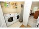 Practical laundry room with washer, dryer, shelving, and ironing board for convenient chores at 1605 Heritage Club Ave, Wake Forest, NC 27587
