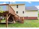 Expansive backyard view showcases a wooden deck and stairs, enhanced by lush greenery at 1614 Finnsbury Dr, Burlington, NC 27217