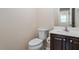 A bathroom featuring a dark wood vanity with a sink and a toilet with matching hardware at 1614 Finnsbury Dr, Burlington, NC 27217