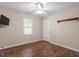 Bedroom featuring ceiling fan, window, wood floors and wall-mounted television at 1614 Finnsbury Dr, Burlington, NC 27217