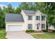 Inviting home with blue shutters, attached garage, and American flag display at 1614 Finnsbury Dr, Burlington, NC 27217