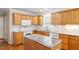 An updated kitchen with wooden cabinets, a white tiled backsplash, and a granite countertop island at 1614 Finnsbury Dr, Burlington, NC 27217