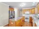 A well-lit kitchen featuring wooden cabinets, stainless steel appliances, and an island with a granite countertop at 1614 Finnsbury Dr, Burlington, NC 27217
