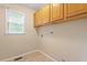 A utility room features built in cabinets, a window for natural lighting, and tile flooring at 1614 Finnsbury Dr, Burlington, NC 27217