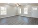Bright living room with large windows, hardwood floors, ceiling fan, and fresh paint at 175 Tupelo Dr, Spring Hope, NC 27882