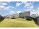 Expansive backyard featuring lush green grass, an iron fence, and a modern two-story house under a bright sky at 19 Cecina Ct, Clayton, NC 27527