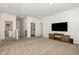 Large bonus room with a media center, big-screen TV, and multiple doors to other rooms at 19 Cecina Ct, Clayton, NC 27527