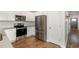 Stainless steel appliances complement the white cabinetry and hardwood flooring in this modern kitchen at 19 Cecina Ct, Clayton, NC 27527