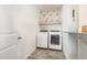 Functional laundry room with modern washer and dryer, decorative shelf, and stylish wallpaper at 19 Cecina Ct, Clayton, NC 27527