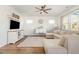 Living room with hardwood flooring, ceiling fan, large windows, tv and ample seating at 19 Cecina Ct, Clayton, NC 27527