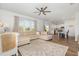 Open concept living room with view to the kitchen, a ceiling fan, and modern decor at 19 Cecina Ct, Clayton, NC 27527