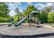 Community playground featuring slides, climbing structures, and a soft landing surface under a blue sky with trees at 19 Cecina Ct, Clayton, NC 27527