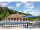Outdoor community pool area featuring comfortable lounge chairs and umbrellas under the bright sunshine with lush green trees at 19 Cecina Ct, Clayton, NC 27527