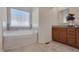 Relaxing bathroom with soaking tub, granite countertop vanity, tile floors, and natural light at 1904 Birdhouse Ln, Wake Forest, NC 27587