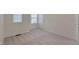 Well-lit bedroom with plush carpet, neutral paint, two windows, and a door to enhance functionality at 1904 Birdhouse Ln, Wake Forest, NC 27587