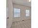 Bright bedroom with neutral carpet, two windows and a door at 1904 Birdhouse Ln, Wake Forest, NC 27587