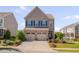Charming two-story brick home featuring a two-car garage, well-manicured lawn, and colorful landscaping at 1904 Birdhouse Ln, Wake Forest, NC 27587