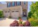 Beautiful two-story brick home featuring a two-car garage, black shutters, and well manicured landscaping at 1904 Birdhouse Ln, Wake Forest, NC 27587
