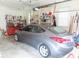 A gray Hyundai Elantra parked inside a spacious two-car garage with storage and tools at 2000 Howson Rd, Raleigh, NC 27603