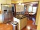 Open kitchen layout with stainless steel refrigerator, island with granite countertop and hardwood floors at 2000 Howson Rd, Raleigh, NC 27603